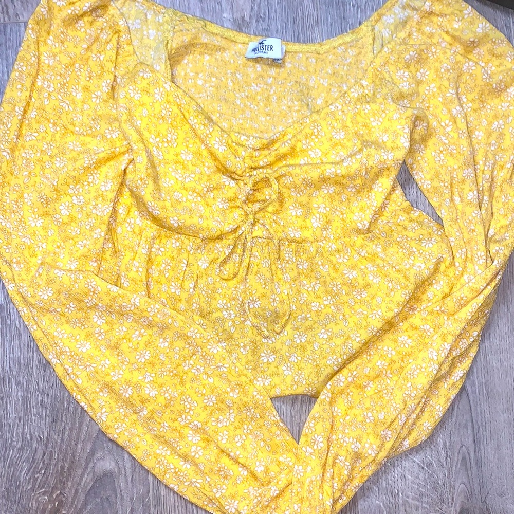 A yellow flower long sleeve. Has a tied ribbon in the middle.